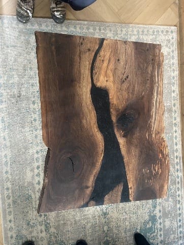 Bovenaanzicht van het houten tafelblad met een donkere rivier van epoxy
