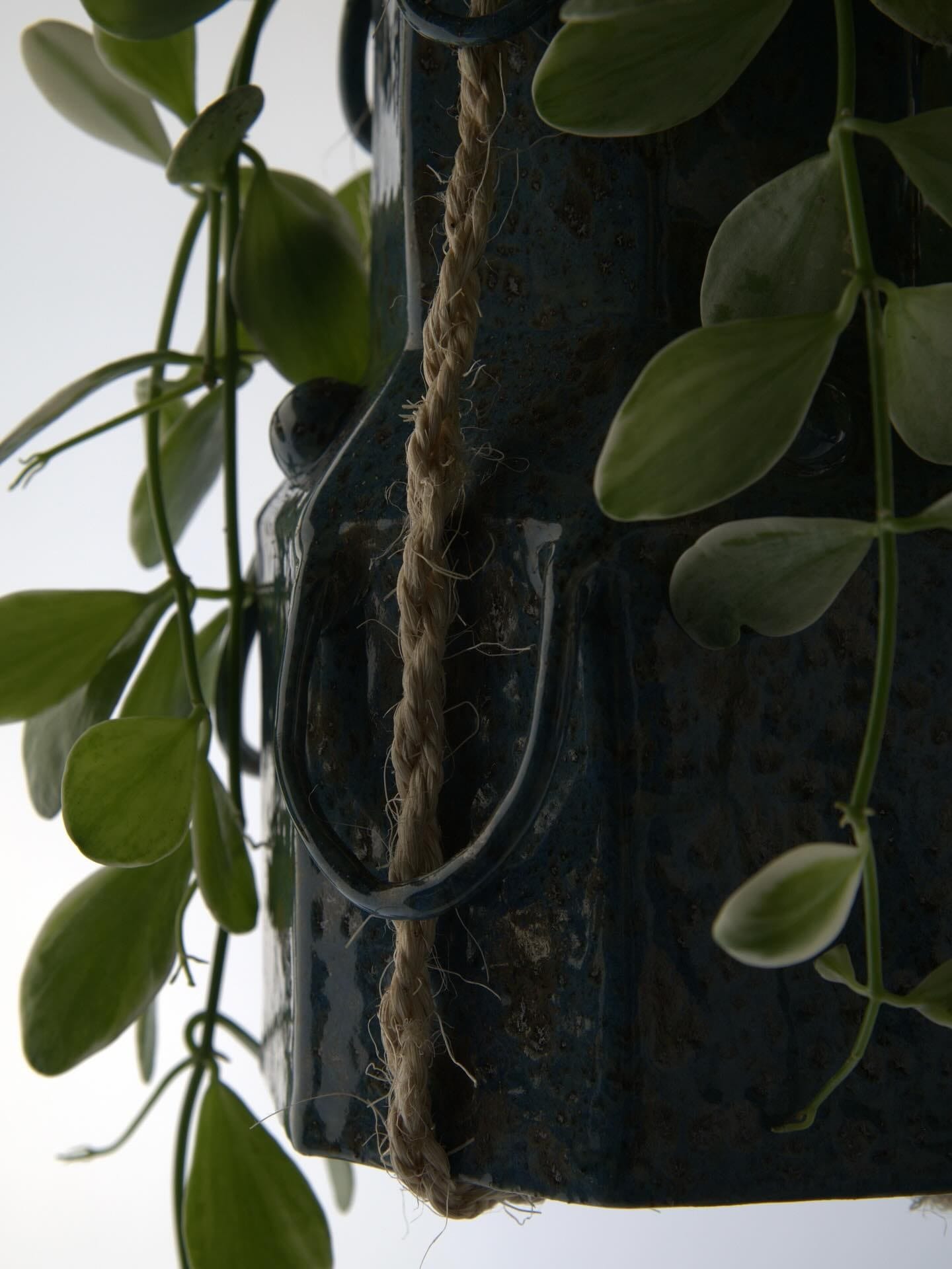 Detail van de hangpot: oortjes, jute touw en glanzend blauw glazuur