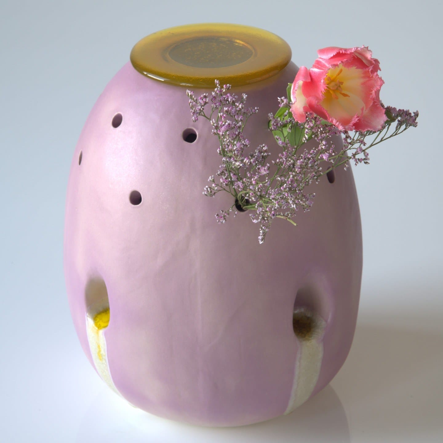 De lila vaas Bijziend van dichtbij met een roze tulp en kleine bloemen in de gaatjes