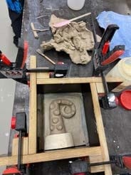 Een geboetseerd model in een houten bekisting met lijmklemmen