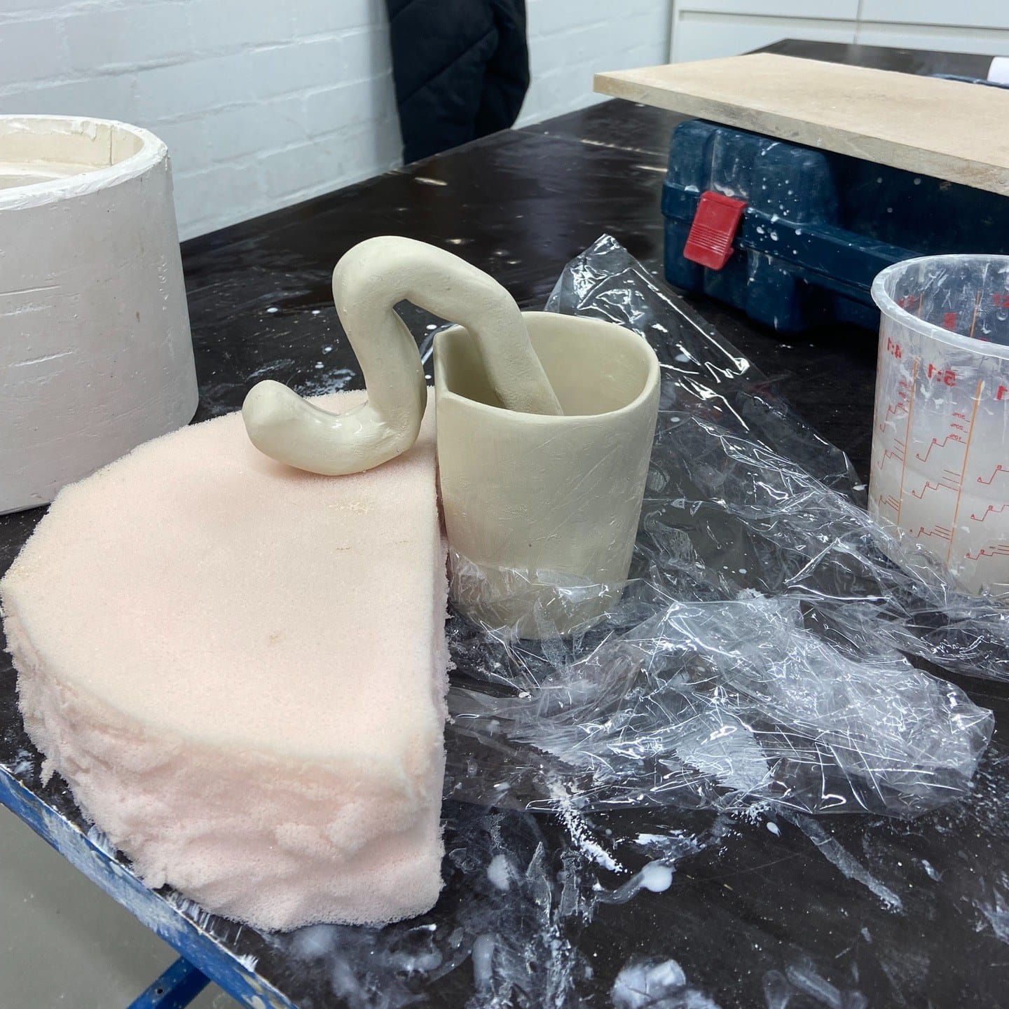 Bekers en slangenoor in klei op de werktafel