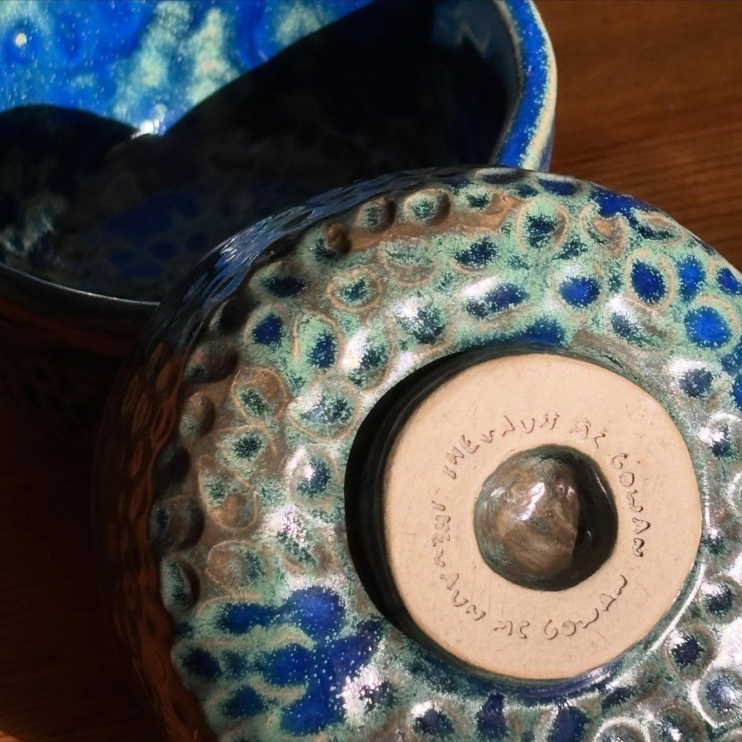 Detail van de gestempelde voet en de gehamerde, blauwgroene buitenkant