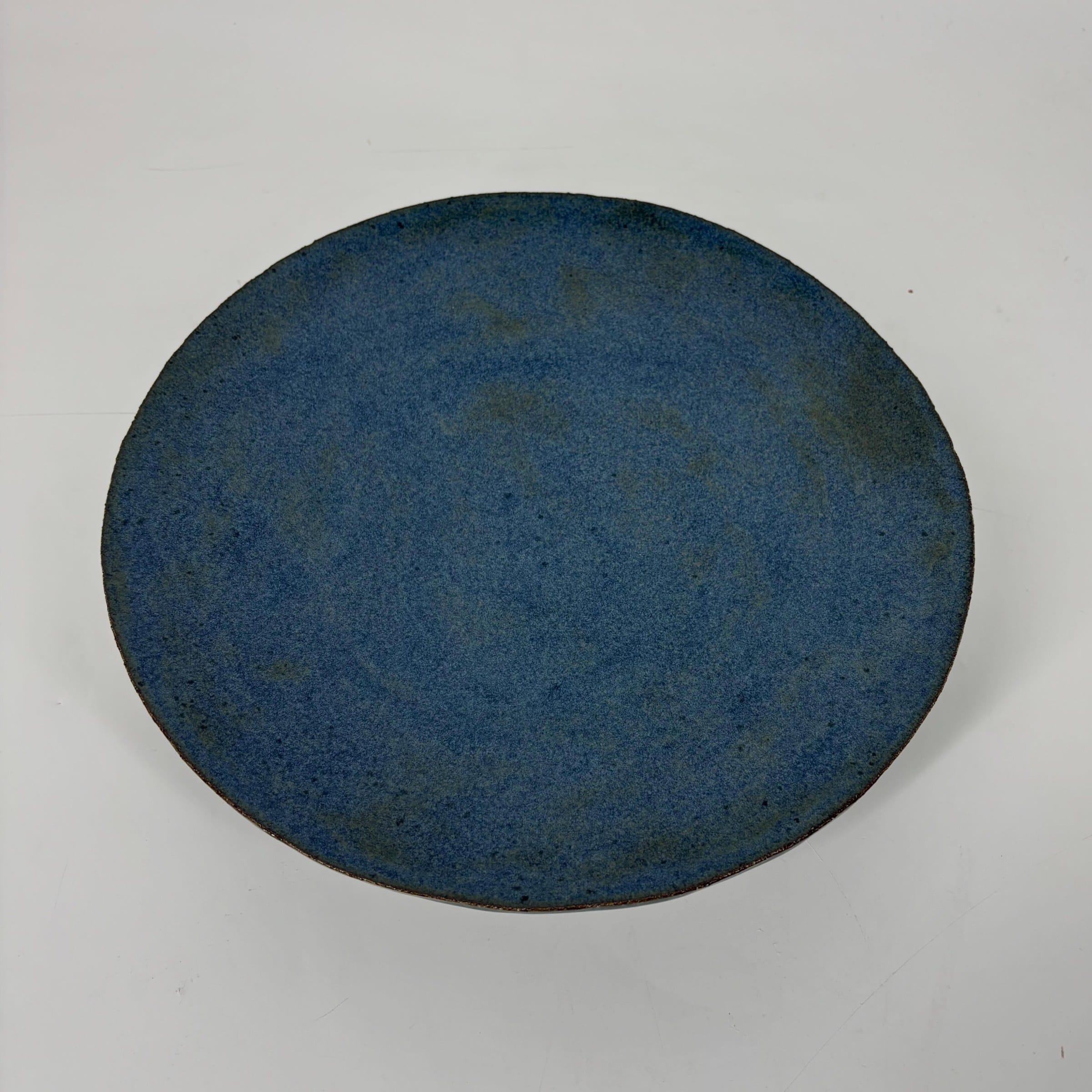 Blauw bord van bovenaf met een gespikkeld mat glazuur