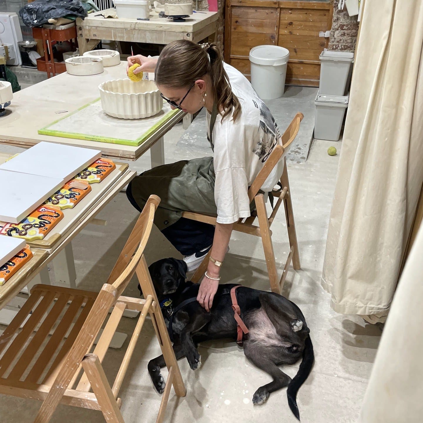 Aan de werktafel, met een zwarte hond die ernaast op de grond ligt